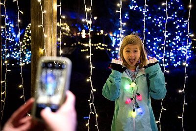 2019 New England Botanic Garden at Tower Hill Night Lights An evening image of a young girl posing for a photo next to multicolored lights.