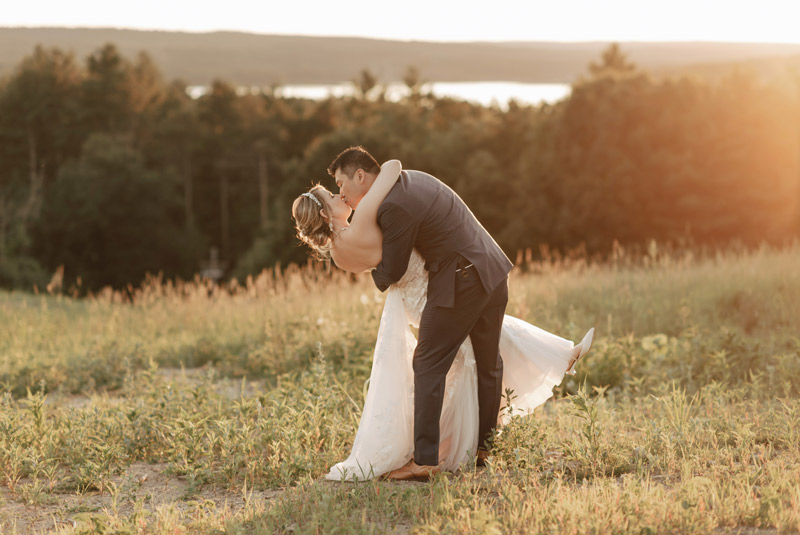 A couple takes a photo in one of the Garden's meadow areas. The sun is setting behind them.