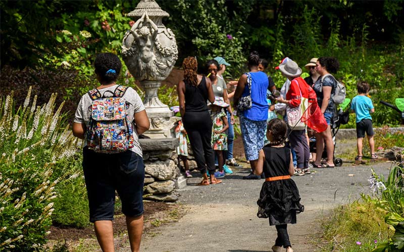 Children running around the garden with nets.