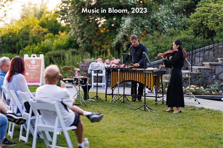 Visitors sit in the Secret Garden listening to live music during Music in Bloom.