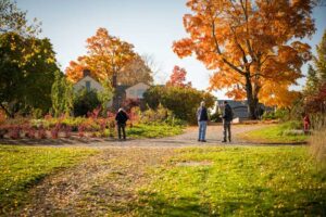 Visitors walking up the the Vegetable Garden surrounded by fall foliage.