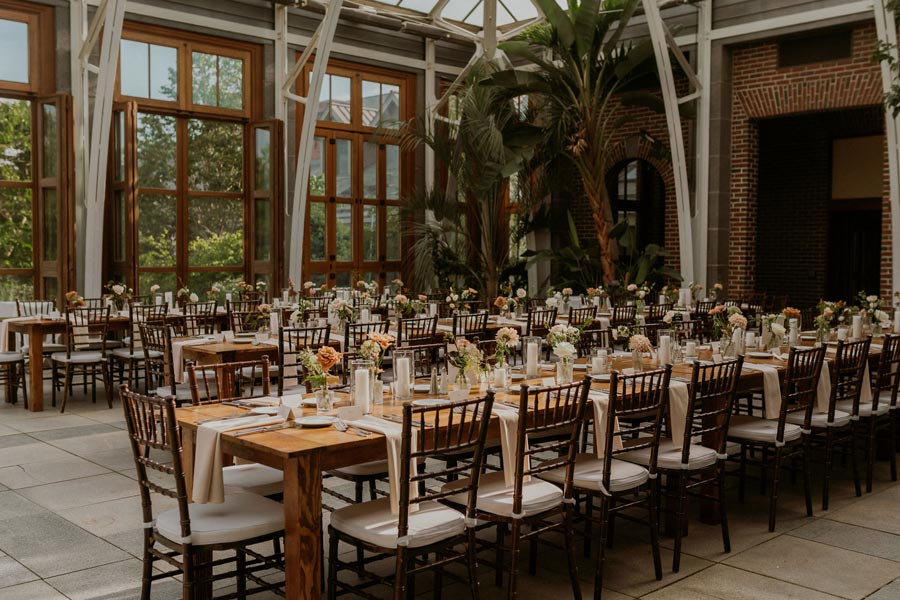 Tables set up for a wedding ceremony in the Orangerie.