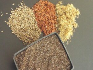 Multiple seeds scattered on a solid surface and a displayed tray of seeds