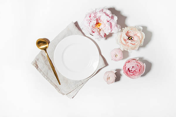 1afternoon-tea set of flowers and dinner plate on a stark white table