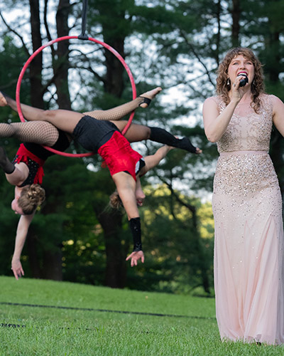 A singer and two acrobats on a hoop