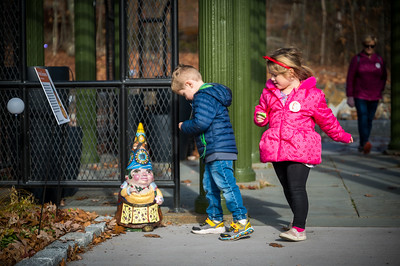 Children standing next to a gnome