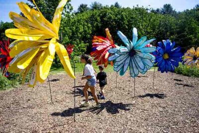 Children playing in large flower displays for an outdoor exhibit